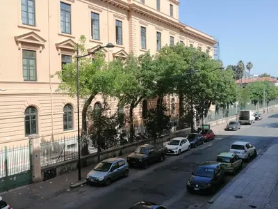 a street with cars parked in front of a building at Silvia's House in Palermo