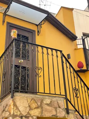 a yellow house with a black door at Casa vacanze donna Pina in Palermo