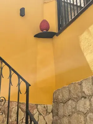 a yellow wall with a staircase with a potted plant at Casa vacanze donna Pina in Palermo