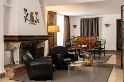 a living room with black chairs and a fireplace at Hotel Principe Di Villafranca in Palermo