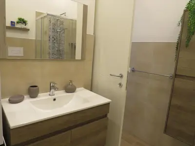 a bathroom with a sink and a shower at TRISOLE Palermo in Palermo