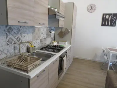 a kitchen with a sink and a stove top oven at TRISOLE Palermo in Palermo