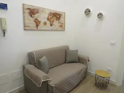 a living room with a couch and a map on the wall at TRISOLE Palermo in Palermo