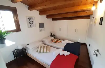 two beds in a room with wooden ceilings at [TERRACE WITH VIEW] Attic in old town BallarHome in Palermo