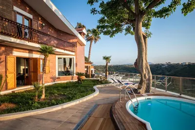 a villa with a swimming pool and a house at Villa vista mare con piscina riscaldata a Trappeto in Balestrate