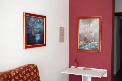 a room with a white table and paintings on the wall at PalerMonAmour Art Gallery Suite in Palermo