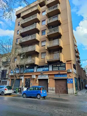 a blue car parked in front of a tall building at casadifederica in Palermo