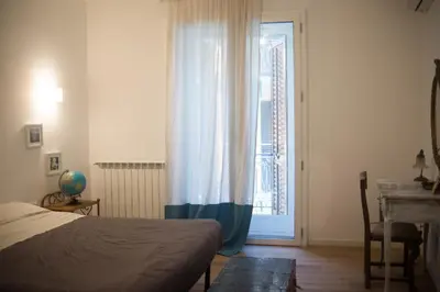 a bedroom with a bed and a window and a desk at via pannieri apartament in Palermo