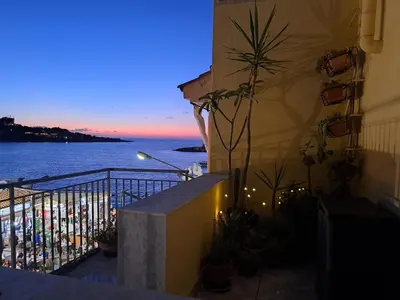 a balcony with a view of the ocean at night at La casetta al mare in Palermo