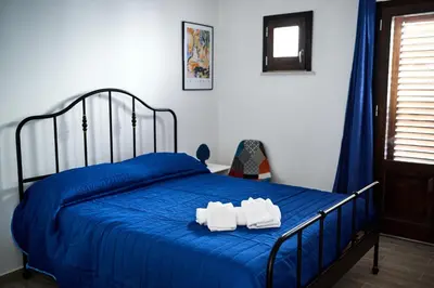 a bedroom with a blue bed with two towels on it at Mercede Rooms in Palermo
