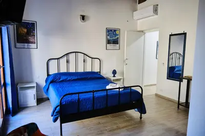 a bedroom with a bed with blue sheets and a window at Mercede Rooms in Palermo