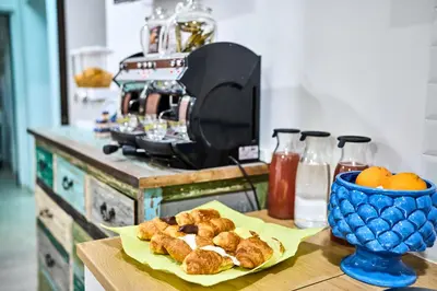 a table with a plate of pastries and a bowl of oranges at Mercede Rooms in Palermo