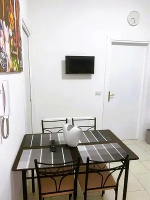 a dining room table with two chairs and a television at The traveler's house in Palermo