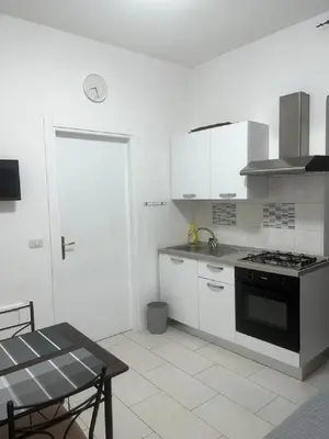 a kitchen with white cabinets and a stove top oven at The traveler's house in Palermo