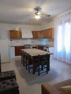 a kitchen with a table and chairs in a room at Lumera in Santa Flavia