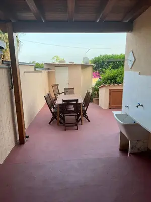 a patio with a table and chairs on a balcony at Lumera in Santa Flavia
