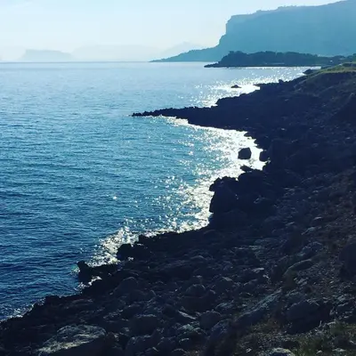 a group of rocks on the shore of the ocean at Mondello Addaura Addisio Suite in Palermo