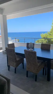 a blue table and chairs with a view of the ocean at Mondello Addaura Addisio Suite in Palermo