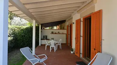 a patio with chairs and a table and a table and chairs at Chalet Calarossa in Terrasini