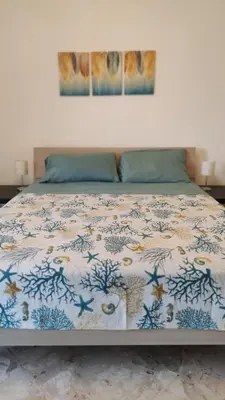 a bed with a comforter with fishes on it at Amunì in Palermo