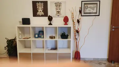 a white book shelf in a room with vases at Amunì in Palermo