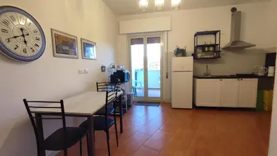 a kitchen and dining room with a clock on the wall at Amunì in Palermo