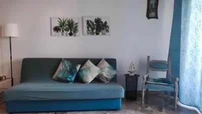 a living room with a blue couch and a chair at Amunì in Palermo