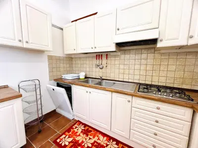 a kitchen with white cabinets and a sink at Nonna Sasà in Torretta