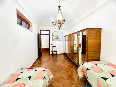 a bedroom with two beds and a chandelier at Nonna Sasà in Torretta