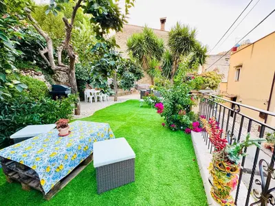 a garden with a table and flowers on a balcony at Nonna Sasà in Torretta