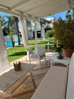 a patio with two white chairs and a table at Villa Losanna in Mondello