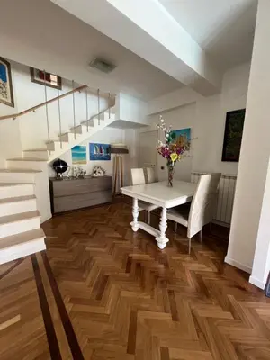 a dining room with a white table and stairs at Villa Losanna in Mondello