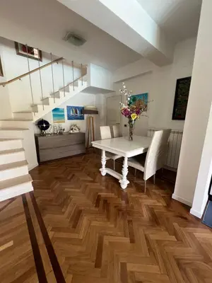 a dining room with a white table and stairs at Villa Losanna in Mondello