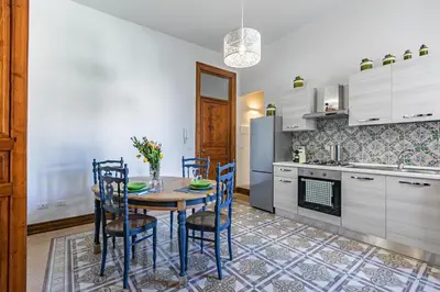 a kitchen with a table and chairs in a room at GuestHost - Terry's Garden in Palermo in Palermo