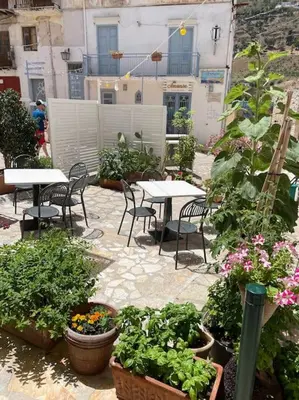 an outdoor patio with tables and chairs and plants at Appartamento L'Agnuni in Castellammare del Golfo