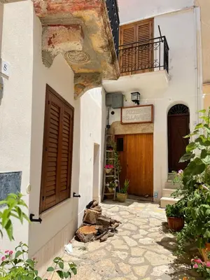 an alley with a building with a door and a balcony at Appartamento L'Agnuni in Castellammare del Golfo