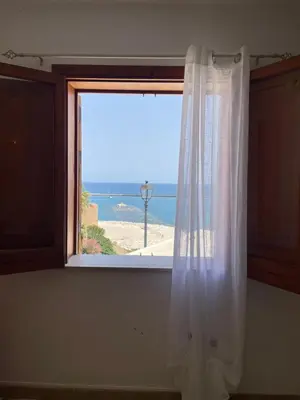 a window with a view of a beach at Appartamento L'Agnuni in Castellammare del Golfo