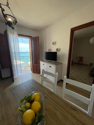a kitchen and dining room with a table with a bowl of fruit at Appartamento L'Agnuni in Castellammare del Golfo
