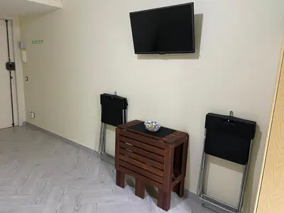a room with a tv on the wall and a table at Residence _Capo Gallo in Palermo