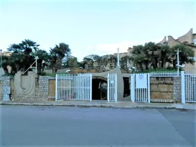 a white gate in front of a building with trees at Residence _Capo Gallo in Palermo