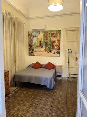 a bedroom with a bed and a painting on the wall at Nowhere Rooms in Palermo
