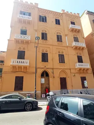 a building with cars parked in front of it at Nowhere Rooms in Palermo