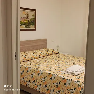 a bedroom with a bed with a comforter on it at Lilibet Apartment in Palermo