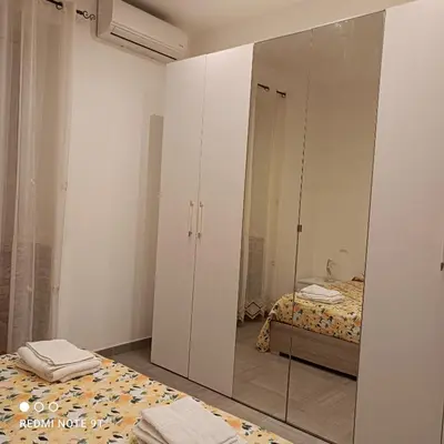 a bedroom with a mirrored wardrobe and a bed at Lilibet Apartment in Palermo