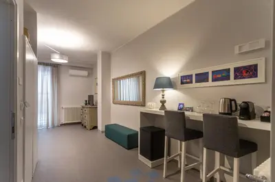 a room with a kitchen with a counter and chairs at Isula in Palermo