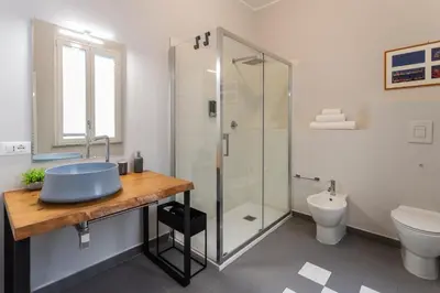 a bathroom with a sink and a glass shower at Isula in Palermo