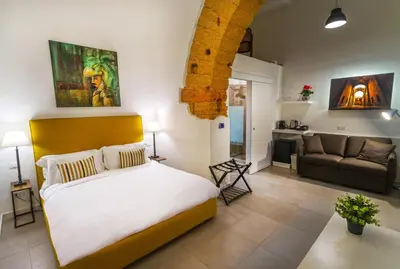 a bedroom with a bed and a living room with a couch at Isula in Palermo