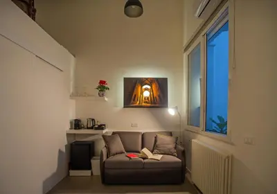 a living room with a couch with a book on it at Isula in Palermo