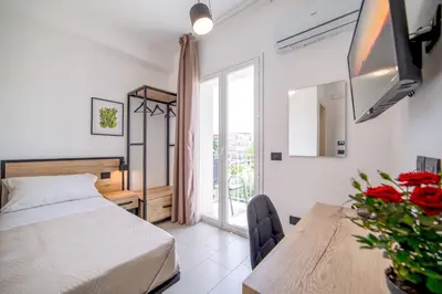 a bedroom with a bed and a table and a window at Ciuri' Affittacamere in Alcamo