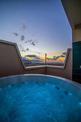 a hot tub in a room with a view of the ocean at Ciuri' Affittacamere in Alcamo